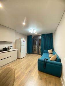 a living room with a blue couch in a kitchen at Shaika resort Bibllan apartmens in Chon-Sary-Oy