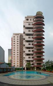 ein Gebäude mit einem Pool vor einem Gebäude in der Unterkunft Midtown Residence Simatupang Jakarta in Jakarta