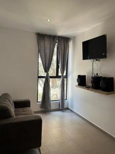a living room with a couch and a large window at Departamento nuevo completo Zoologico GDL in Guadalajara