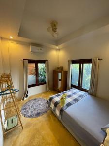 een slaapkamer met een bed, een ladder en ramen bij The Peaceful Villa No2 in Thongsala