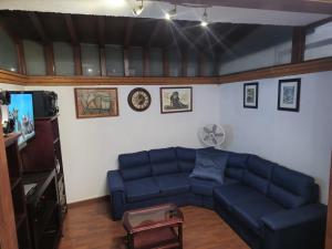 a living room with a blue couch and a tv at Casa en zona residencial in Oaxaca City