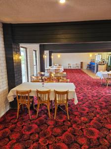 a large room with a table and chairs on a red carpet at Stockman Motor Inn in Narromine +19 photos