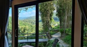 a sliding glass door with a view of a forest at NantraKiri in Ban Na Kham