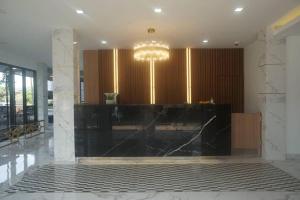 eine Lobby mit einem schwarzen Tresen und einem Kronleuchter in der Unterkunft Prinn Hotel in Ban Thai Wat Khot