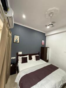 a bedroom with a large bed with a blue wall at Hotel Shiv Palace Yoga World Retreat in Rishīkesh +56 photos