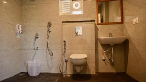 een badkamer met een douche, een toilet en een wastafel bij Heritage Suites in Mysore