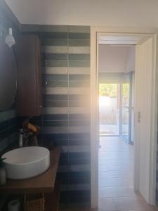 a bathroom with a white sink and a doorway at Louloudi in Káto Alepokhórion +18 photos