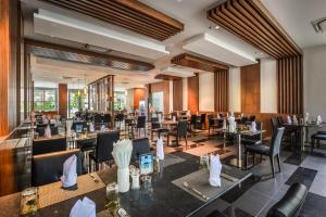 a restaurant with tables and chairs in a room at Fishermens Harbour Urban Resort - SHA Extra Plus in Patong Beach