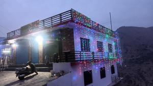 a house with christmas lights on the side of it at Kanha Homestay and restaurant in Dhanaulti