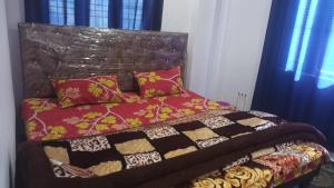 a bed with a quilt and pillows in a bedroom at Kanha Homestay and restaurant in Dhanaulti