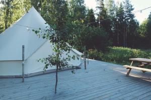 a tent on a wooden deck with a picnic table at Slow Life Sweden - Family Glamping Tent Poppel 