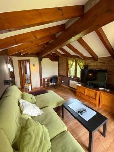 a living room with a couch and a tv at Chalet con zona de asador en Quijas in Valles