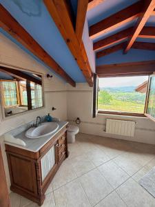 a bathroom with a sink and a toilet and a window at Chalet con zona de asador en Quijas in Valles +49 photos