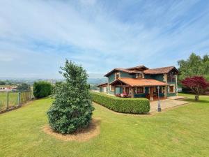 a house with a tree in front of it at Chalet con zona de asador en Quijas in Valles