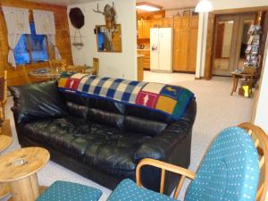 a living room with a black leather couch and chairs at Antler's Rest Bed and Breakfast in Glennallen