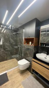 a bathroom with a toilet and a shower and a sink at Тони апартмент in Burgas City