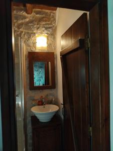 a bathroom with a sink and a mirror at Mani Fort Charabos in Ayía Kiriakí +29 photos