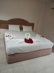 a bed with white sheets and red flowers on it at SS welcome jomtien in Jomtien Beach +9 photos