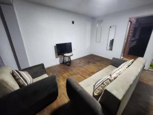 ein Wohnzimmer mit zwei Sofas und einem Flachbildfernseher in der Unterkunft Departamento esmeralda in Chota