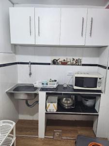 eine kleine Küche mit Spüle und Mikrowelle in der Unterkunft Departamento esmeralda in Chota + 2 Fotos