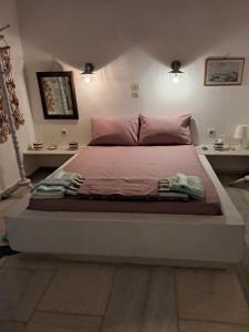 a bedroom with a large bed with pink pillows at OrkiSEA-Orkos beach in Mikri Vigla