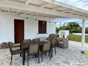a patio with a wooden table and chairs at Casa Tonzi in Orosei