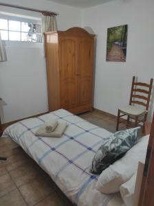 una camera da letto con un letto e un armadio in legno di Verde casa eden a Tías