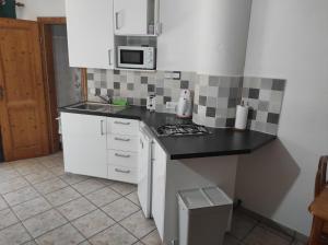 una cucina con mobili bianchi e un piano di lavoro nero di Verde casa eden a Tías Altre 16 foto