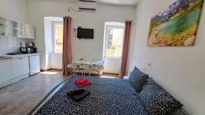 a living room with a bed with a red bag on it at Dejan Apartments-Top centar-Old town-Low budget Studios in Pula