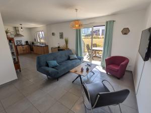 Una sala de estar con un sofá azul y una mesa. en La Belle Paimpolaise, en Paimpol