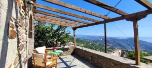 a room with a table and chairs on a balcony with a view at koule Tasoula in Monemvasia