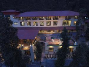 a large white building at night with lights at The Fern Hillside Resort Bhimtal in Bhīm Tāl