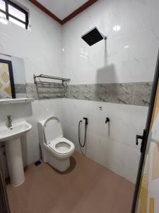 a bathroom with a toilet and a sink at Sha Homestay in Marang +8 photos