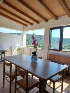 a dining room table with chairs and a vase with flowers on it at Guest House Safigumoru 5 minuti in spiaggia in Bari Sardo