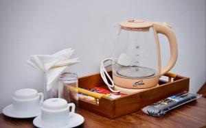 a tea kettle sitting on top of a wooden table at Forest Edge Holiday Inn in Nuwara Eliya