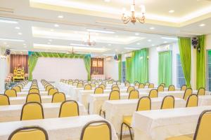 une salle de banquet avec des tables blanches et des chaises jaunes dans l'établissement Villa Reina Resort, à Nong Nam Daeng 49 autres photos