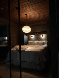 Un dormitorio con una cama grande con una lámpara de araña. en Villa Pikku Karhu, en Kuusamo