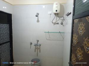 a bathroom with a toilet and a phone on the wall at AC Bed And Breakfast At Pushpanjali Phase 2 Bunglow No A1,Ovale ,Ghodbunder Road Thane West in Thane