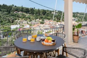 a table with a bowl of fruit on a balcony at Asmira Apartment by PaxosRetreats in Lákka