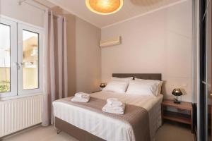 a bedroom with a bed with towels on it at Asmira Apartment by PaxosRetreats in Lákka