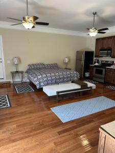 a living room with a bed and a kitchen at MooreField Suites Greensboro East in McLeansville