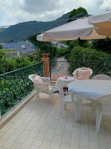 a patio with a table and chairs and an umbrella at Villa Mirabelli in Tropea