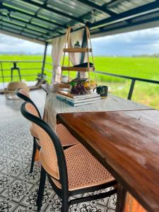 a wooden table with chairs and a book on it at Healing Homestay 