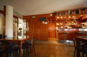 a restaurant with a bar and a table and chairs at Hotel O Cortiço in Sever do Vouga