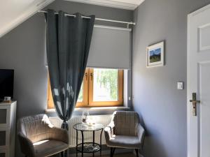 a living room with two chairs and a table and a window at Hajnica GórSki in Wisła