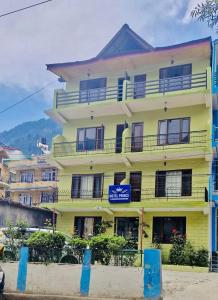Un edificio amarillo con un cartel delante. en HOTEL PRINCE , ALEO , MANALi, en Manali