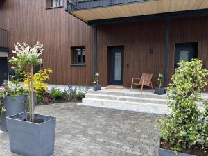 英格堡Genuine mountain holiday apartment in Engelberg的带有露台的建筑，露台上摆放着椅子和植物