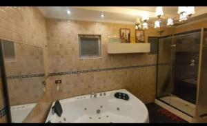 ein Badezimmer mit Badewanne und Fenster in der Unterkunft Pattaya Paradise Pool villa with Garden 3BR in Nong Prue + 10 Fotos