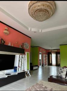 ein Wohnzimmer mit einer Decke und einem Kronleuchter in der Unterkunft Pattaya Paradise Pool villa with Garden 3BR in Nong Prue