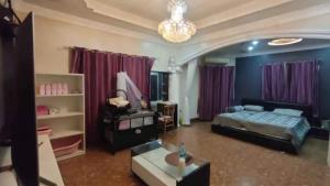 ein Schlafzimmer mit einem Bett und einem Kronleuchter in der Unterkunft Pattaya Paradise Pool villa with Garden 3BR in Nong Prue